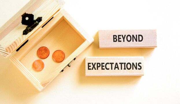 Beyond expectations words symbol. Concept words Beyond expectations on beautiful blocks. Beautiful white background. Wooden chest with coins. Business and Beyond expectations words concept. Copy space