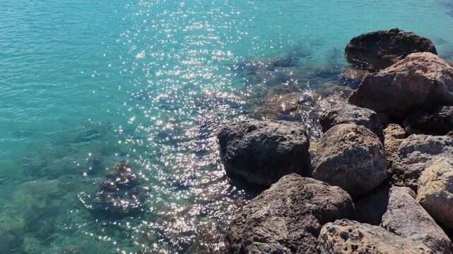 Aerial drone view of a quiet Konnos Beach rocky bay with crystal clear turquoise water in Cyprus
