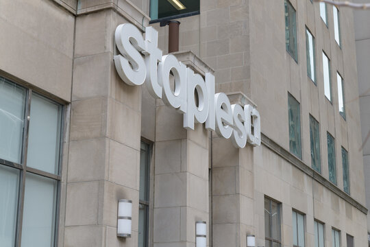 exterior stone facade detail and sign of Staples, an office supply chain, located here at 375 University Av (Armoury St side), Toronto
