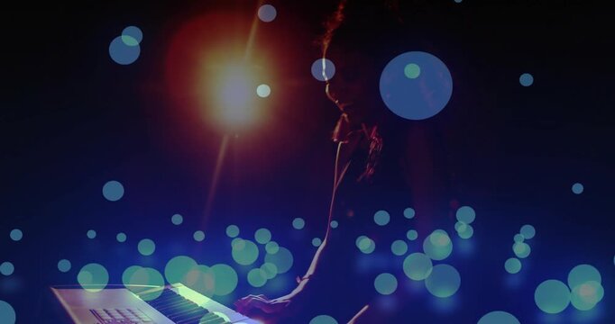 Vertical video: Spotlight appearing, keyboardist playing, hands moving, creating music amid bokeh