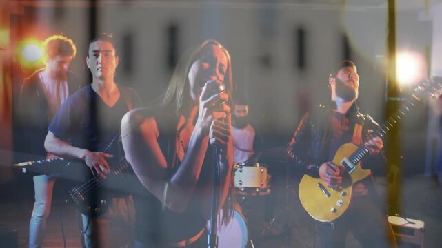 Vertical video: Lights cueing flare overlay on lead singer singing into mic, band driving music