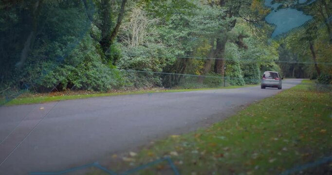 Entering left, silver van moving right along tree-lined road, faint map overlay guiding route