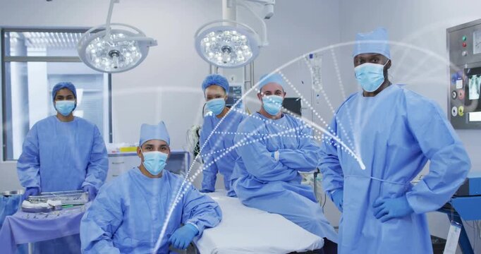 Forming animated arcs, five staff in blue gowns holding position at operating table in hospital OR