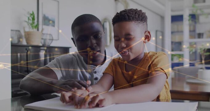 Man reaching forward guiding boy's hands on sheet, animated golden overlay aiding education