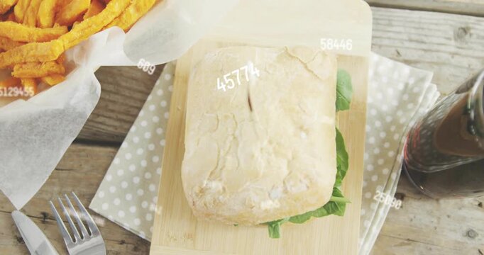 Gloved-hand placing fries by sandwich on board, numbers drifting, camera pulling back, forming meal