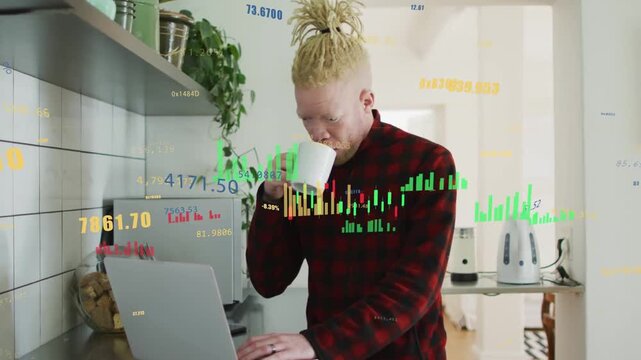 Man at kitchen counter standing, typing laptop while data alert appearing, monitoring market charts