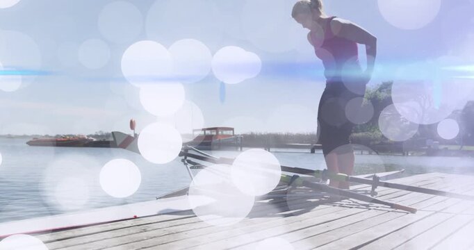 Rower checking rigging on dock, boarding scull for rowing while bokeh overlay drifting over rower