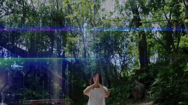 Vertical video: Woman lifting hands from bottom praying sitting on mat meditating amid blue streaks