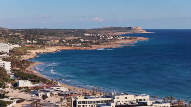 Aerial drone view of the coastline near Ayia Napa, Cyprus, with sandy beach, turquoise sea, and coastal hotels along the Mediterranean shoreline