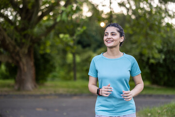 Young woman jogging outdoors, smiling, enjoying healthy exercise
