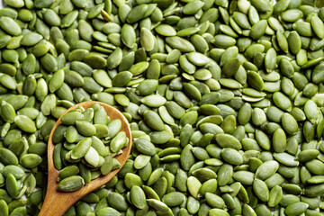 Pumpkin seeds on spoon and background