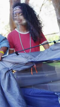 Woman in red shirt stepping, aligning tent pole for festival, animated arrows guiding friends