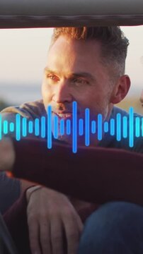 Two mature males talking in parked car at sunset wearing blue shirt and maroon sleeve waveform