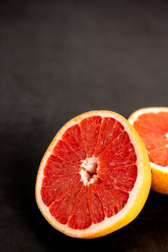 Grapefruit cut in half on a dark surface 
