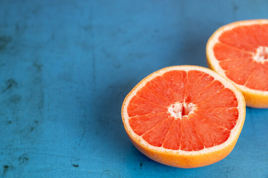 Grapefruit cut in half on colorful surface 