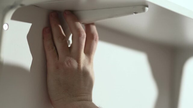  Man marking wall with pencil for shelf installation, DIY home improvement project, 4K 10 bit footage.