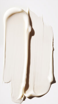 Thick cosmetic cream smeared in vertical strokes on white background.