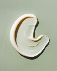 Creamy white cosmetic smear texture on sage green background minimalist swatch. © Artist Protap