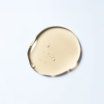 Yellow liquid gel droplet with bubbles on white background cosmetic serum.