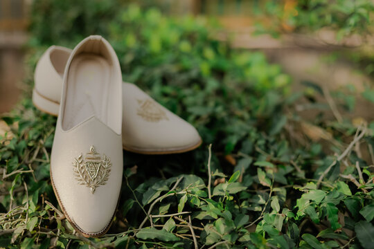 Elegant Cream Khussa Shoes with Gold Embroidery on Lush Green Foliage, Traditional Footwear for Special Occasions and Celebrations
