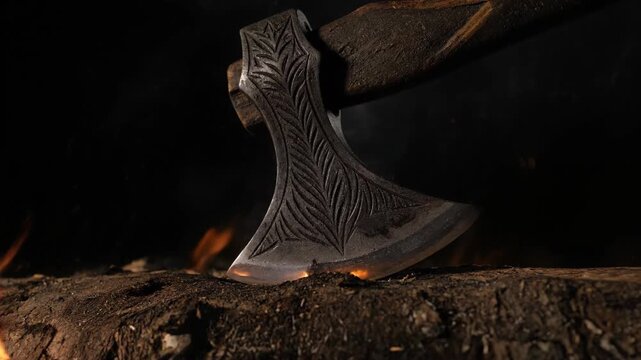 Ancient Viking Axe with Intricate Carvings Near a Campfire.