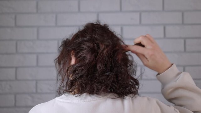 Woman massages her head with a comb
