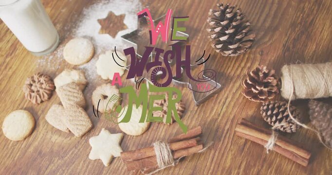 Animation of christmas greetings text over christmas cookies, glass of milk and decorations