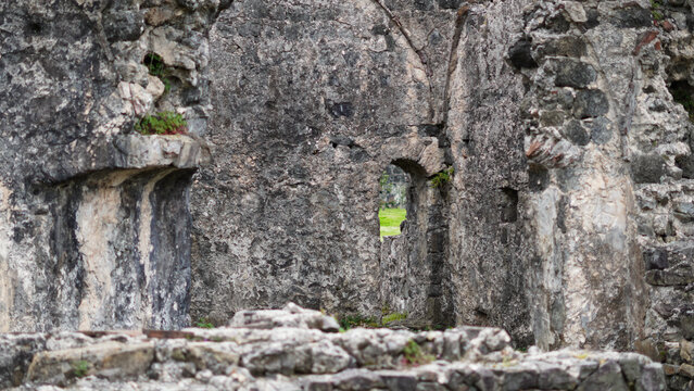 Ancient stone ruins with weathered walls and green grass visible through openings