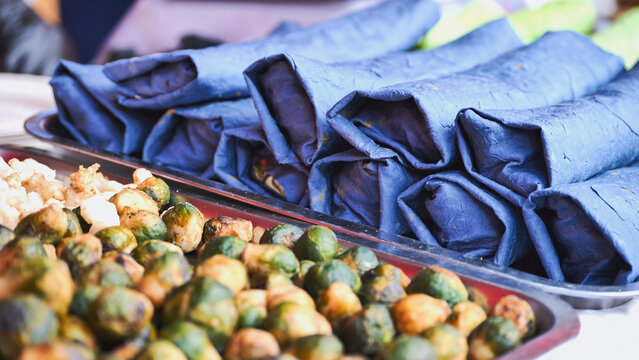 Indian street food vendor preparing traditional kati rolls and roasted brussels sprouts