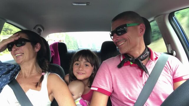 Family singing while driving. Happy father, mother and daughter in a car