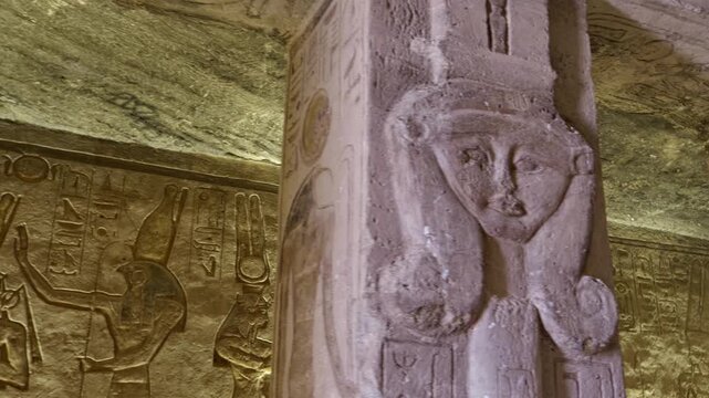 Atmospheric interior of Small Temple of Nefertari at Abu Simbel with carved gods reliefs, hieroglyphics and warm golden lighting, Egypt. Rare inside view for history content.