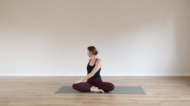 A young woman practicing yoga in a bright modern studio, focusing on balance, breathing, and mindfulness.