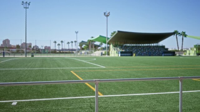 Blurred soccer field and stadium stands with soft bokeh and shallow focus outdoor background; background copyspace backplate calm.