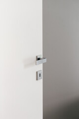 Modern white door with sleek silver handle and keyhole