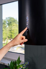 Woman pressing control button on kitchen extractor hood