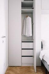 Storage cupboard in an apartment with organized shelves and open door