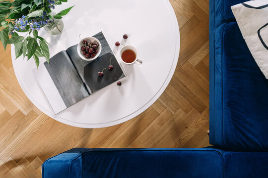 Modern living room coffee table with open book and blue sofa