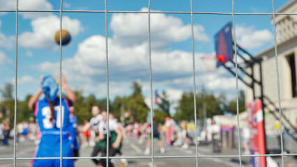 Basketball Game Captured Through Wire Fence on Sports Day © Довидович Михаил