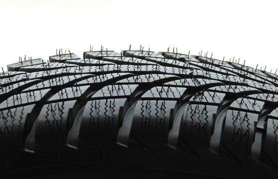 Rubber surface of new car tire with sipes and grooves close up 
