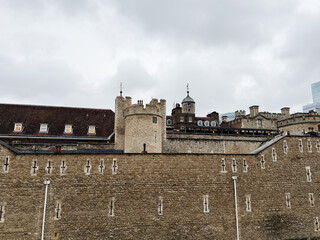 Tower of London historic fortress with stone castle walls and turrets in London, UK under a cloudy sky © AS Photo Family