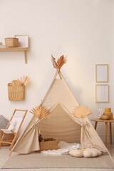Stylish wigwam with dry leaves in child's room © New Africa