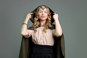 Obraz premium Beautiful girl dressed as elf on grey background