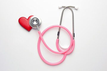 Fototapeta premium Stethoscope and decorative heart on white background, flat lay
