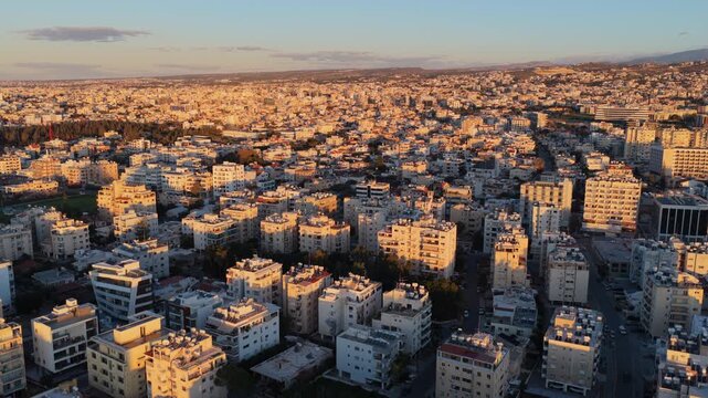 Aerial drone view of Limassol city buildings under warm sunset lighting