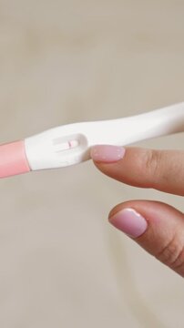 Woman holding in hands pregnancy test. Check quick pregnancy test kit. Vertical footage
