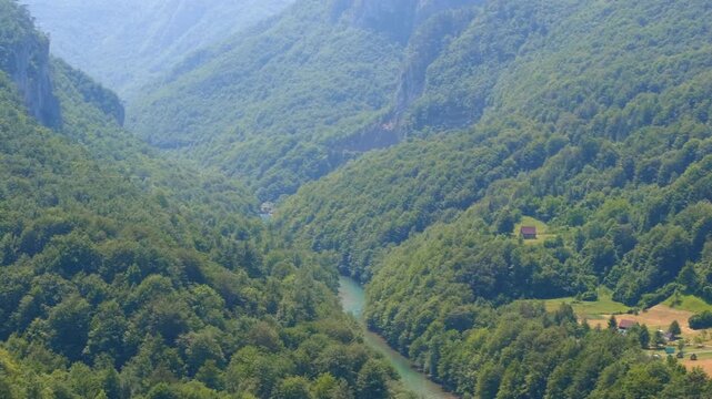 Lush green tara river canyon panning across the valley. Stunning panoramic view of the tara river canyon. Panning from the turquoise water flowing through the deep valley to a charming village