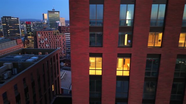 Aerial video of Manchester at sunrise, showing the glow of the morning sun hitting modern red brick towers