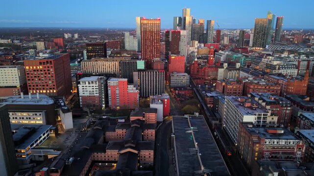 Aerial video of Manchester Skyline at sunrise featuring a passenger train travelling toward Oxford Rd station. 