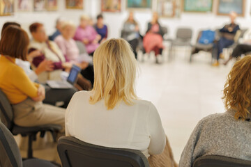 Group of women sitting in a circle during a meeting in a community center focused on discussion and sharing ideas © aerogondo