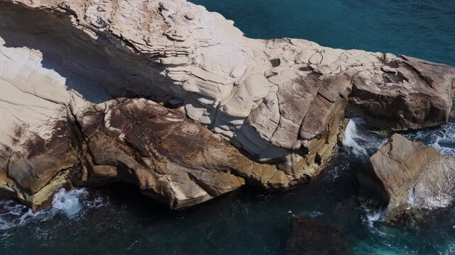 Aerial drone view of rocky coastline with clear blue water near Cape Greco, Cyprus